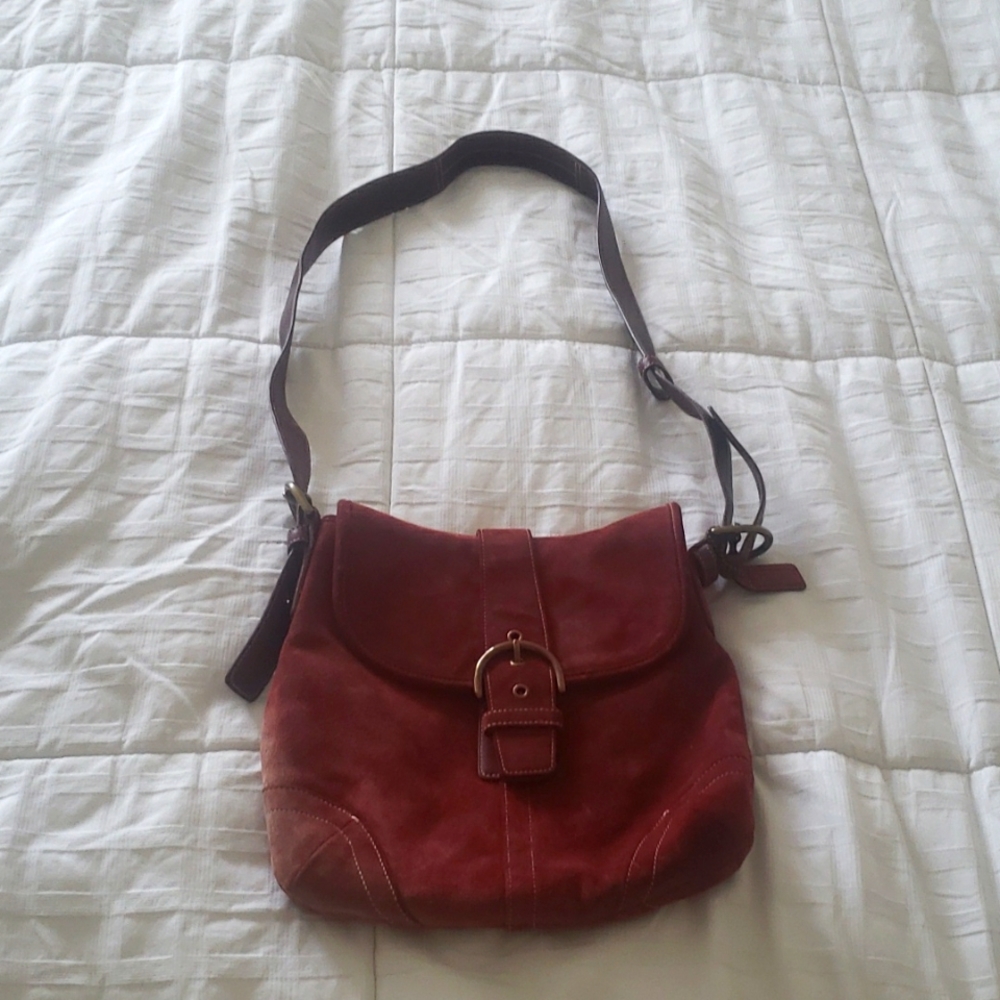 A beautiful maroon swayed coach bag